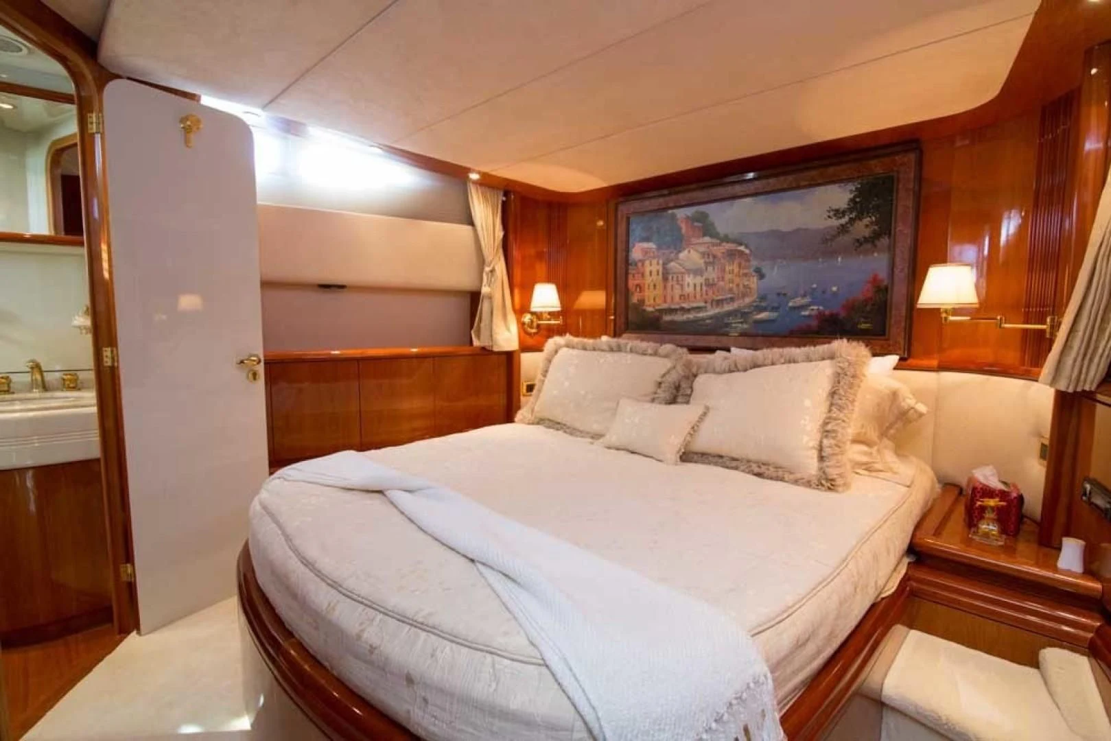 a bed with a white sheet and pillows aboard ENCHANTED LADY Yacht for Sale
