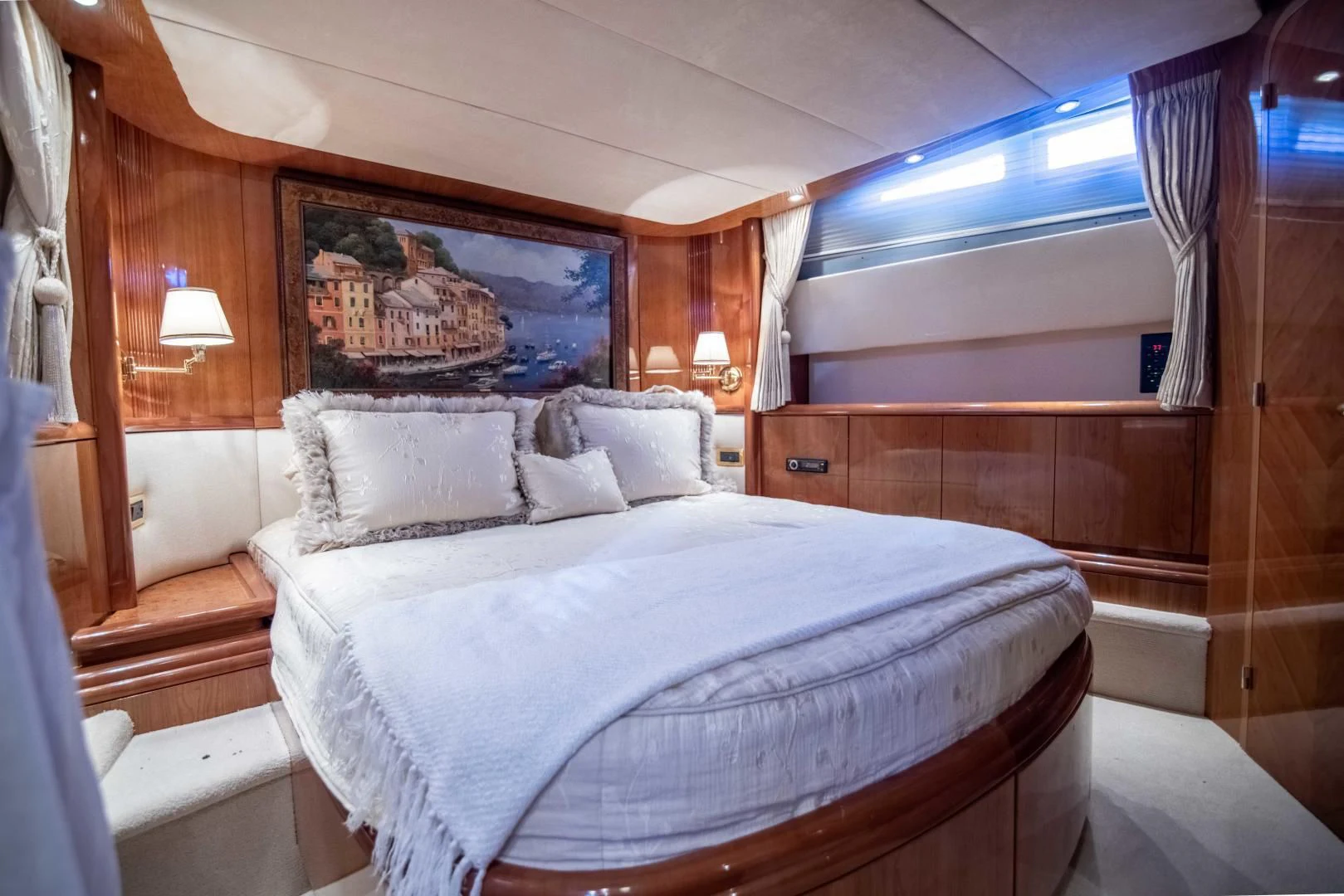 a bed with a white sheet and pillows in a room with wood walls aboard ENCHANTED LADY Yacht for Sale