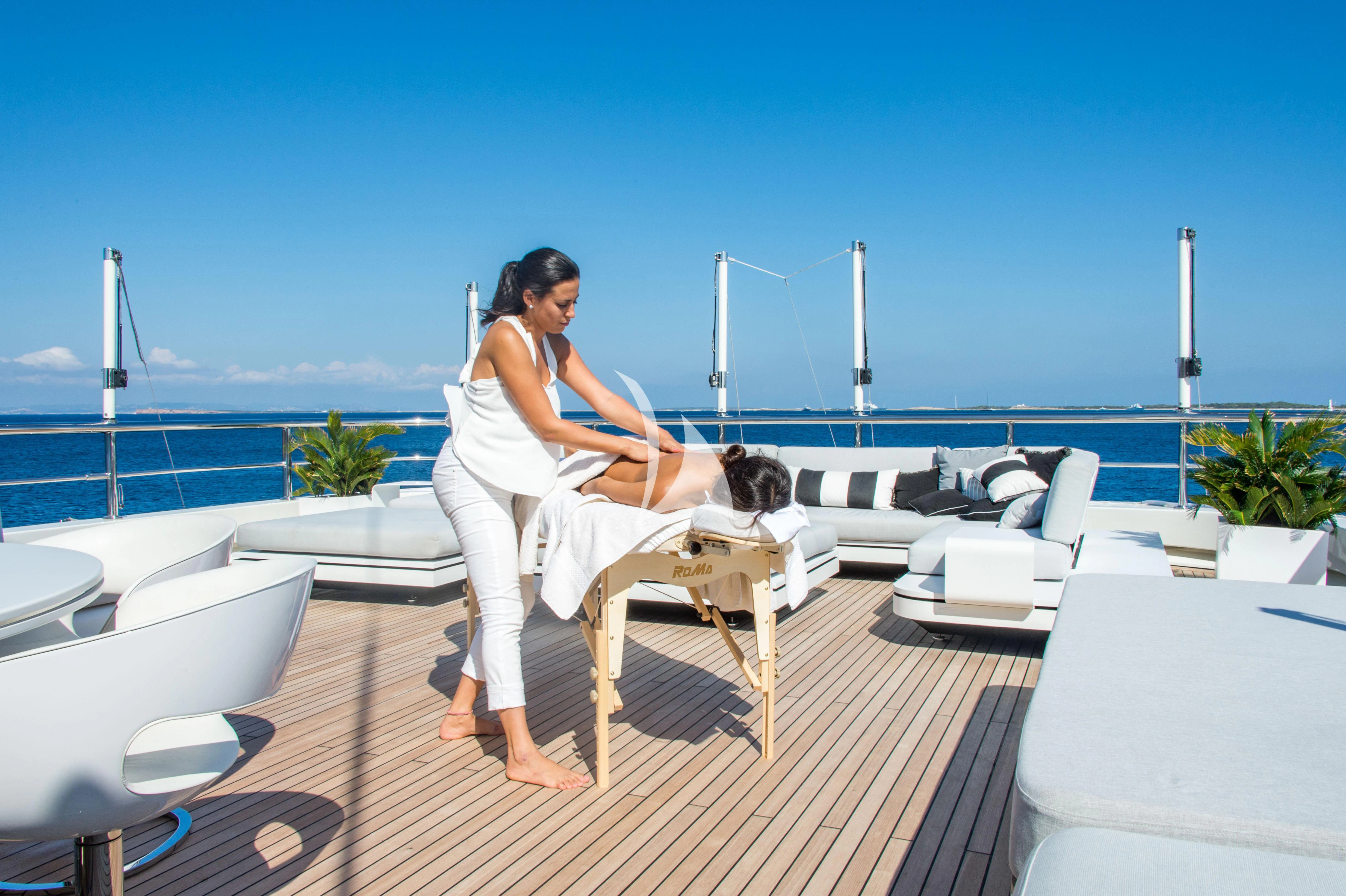 a person sitting on a chair on a deck with a dog aboard ROMA Yacht for Sale