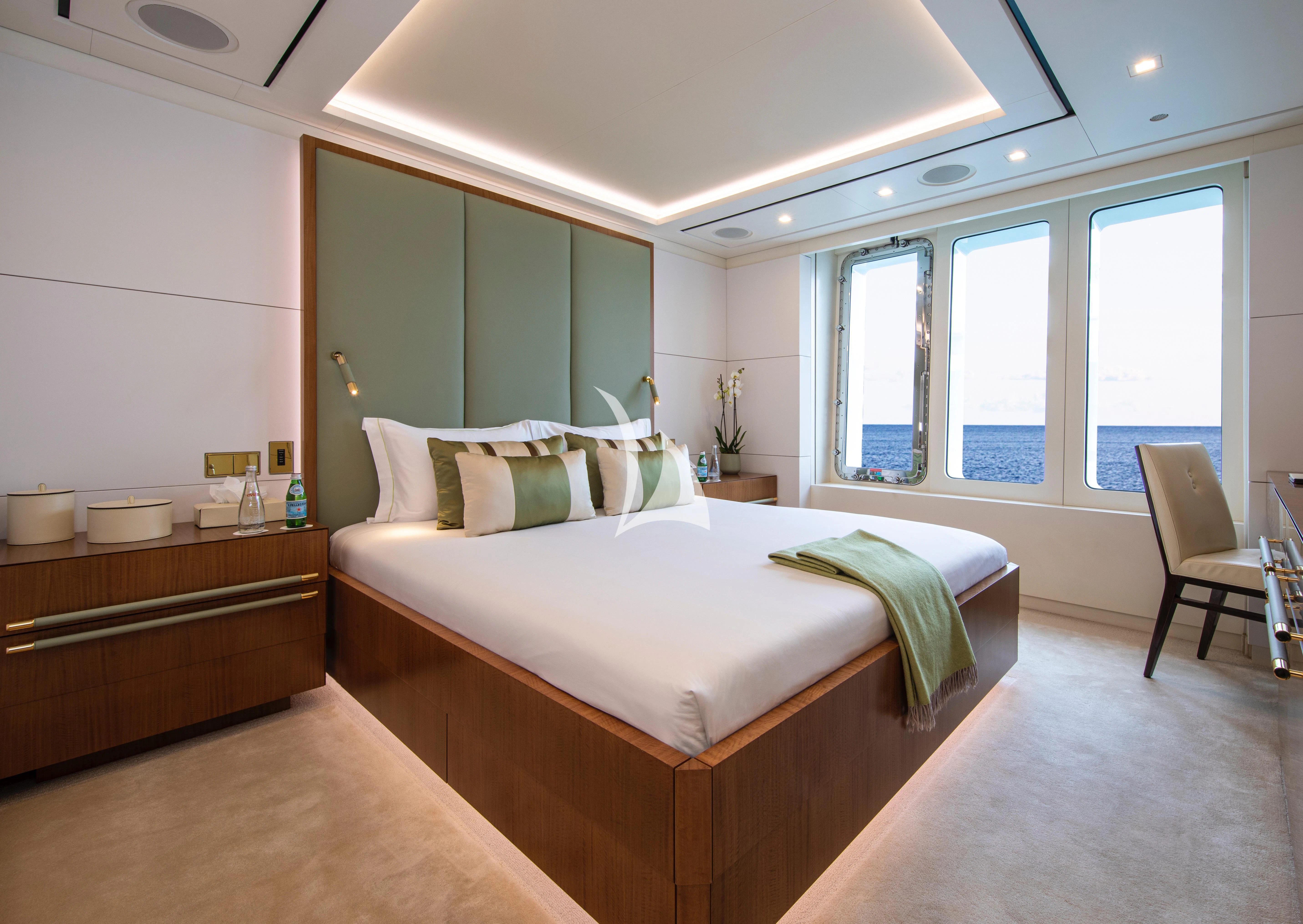 a bedroom with a bed and a chair aboard ROMA Yacht for Sale