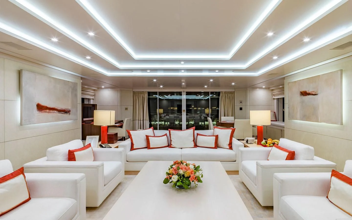 a large white living room with a large white table and white couches aboard ROMA Yacht for Sale