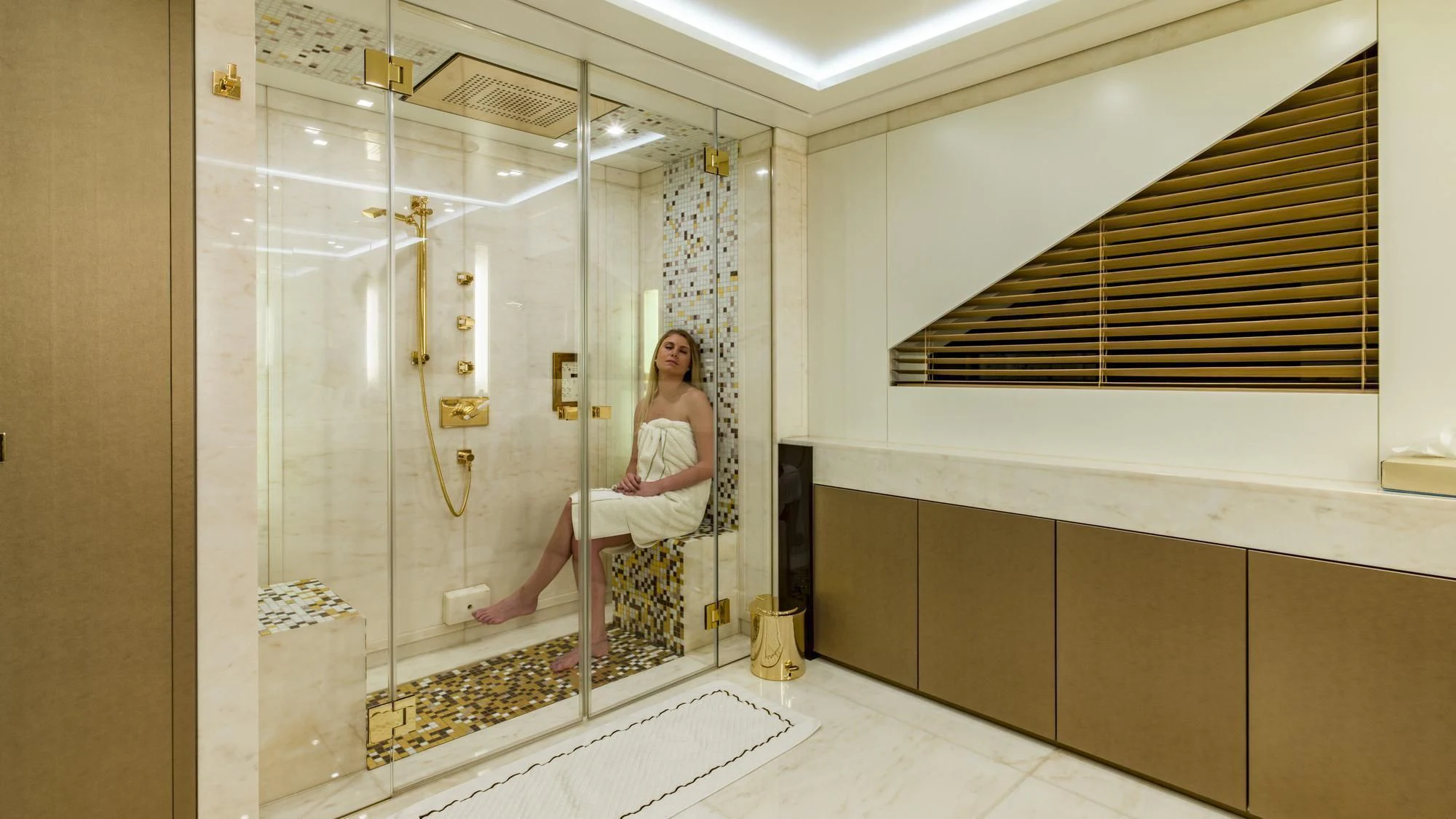 a person sitting on a bench in a bathroom aboard ROMA Yacht for Sale