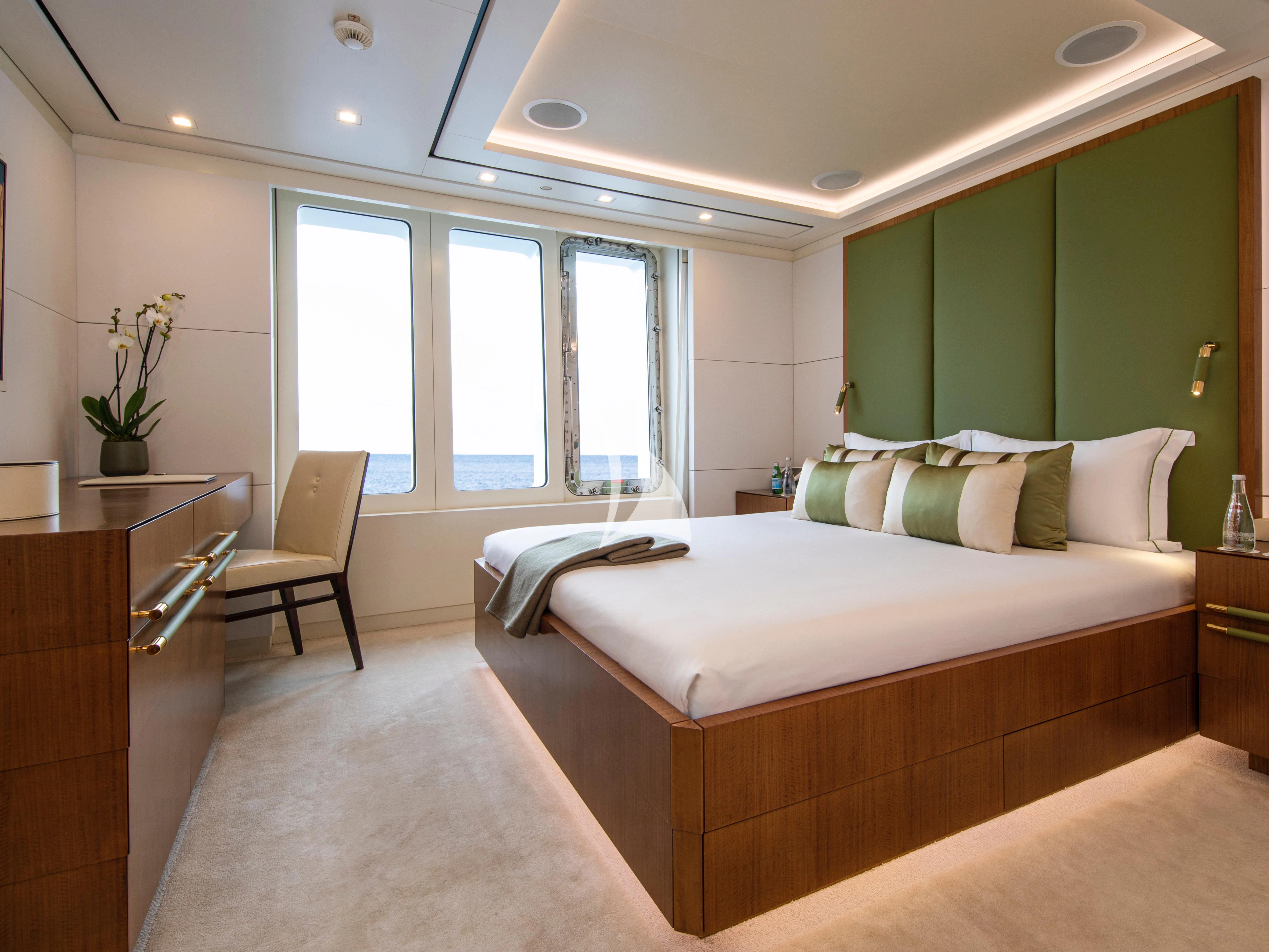 a bedroom with green walls aboard ROMA Yacht for Sale