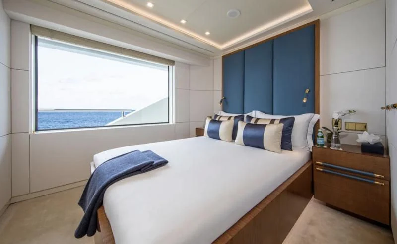 a bedroom with a bed and a window aboard ROMA Yacht for Sale