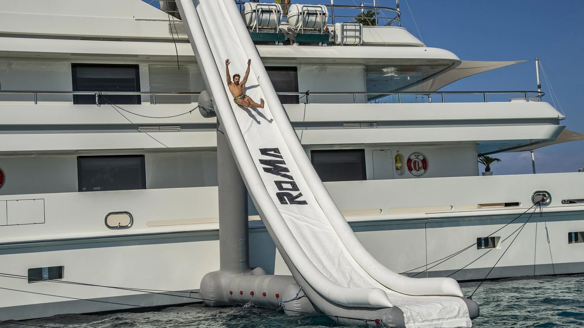 a white boat with a person on the front aboard ROMA Yacht for Sale