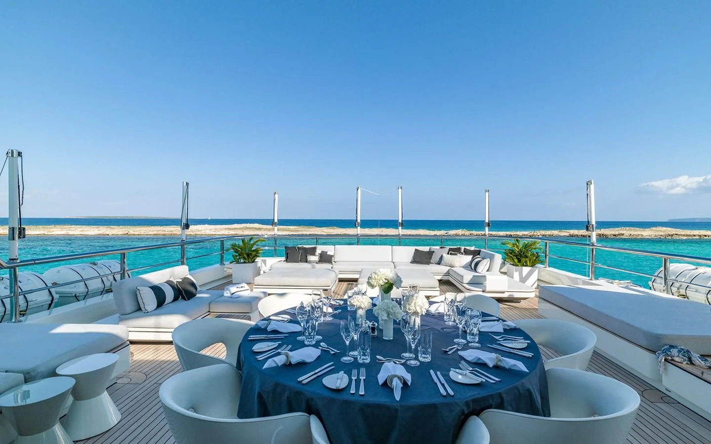 a table with chairs on it next to a pool with flowers on it aboard ROMA Yacht for Sale