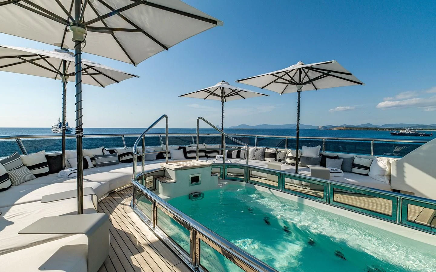a pool with umbrellas and chairs aboard ROMA Yacht for Sale