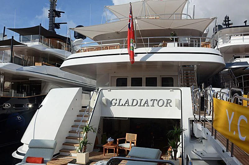 a large white boat with a red flag on the front aboard GLADIATOR Yacht for Sale