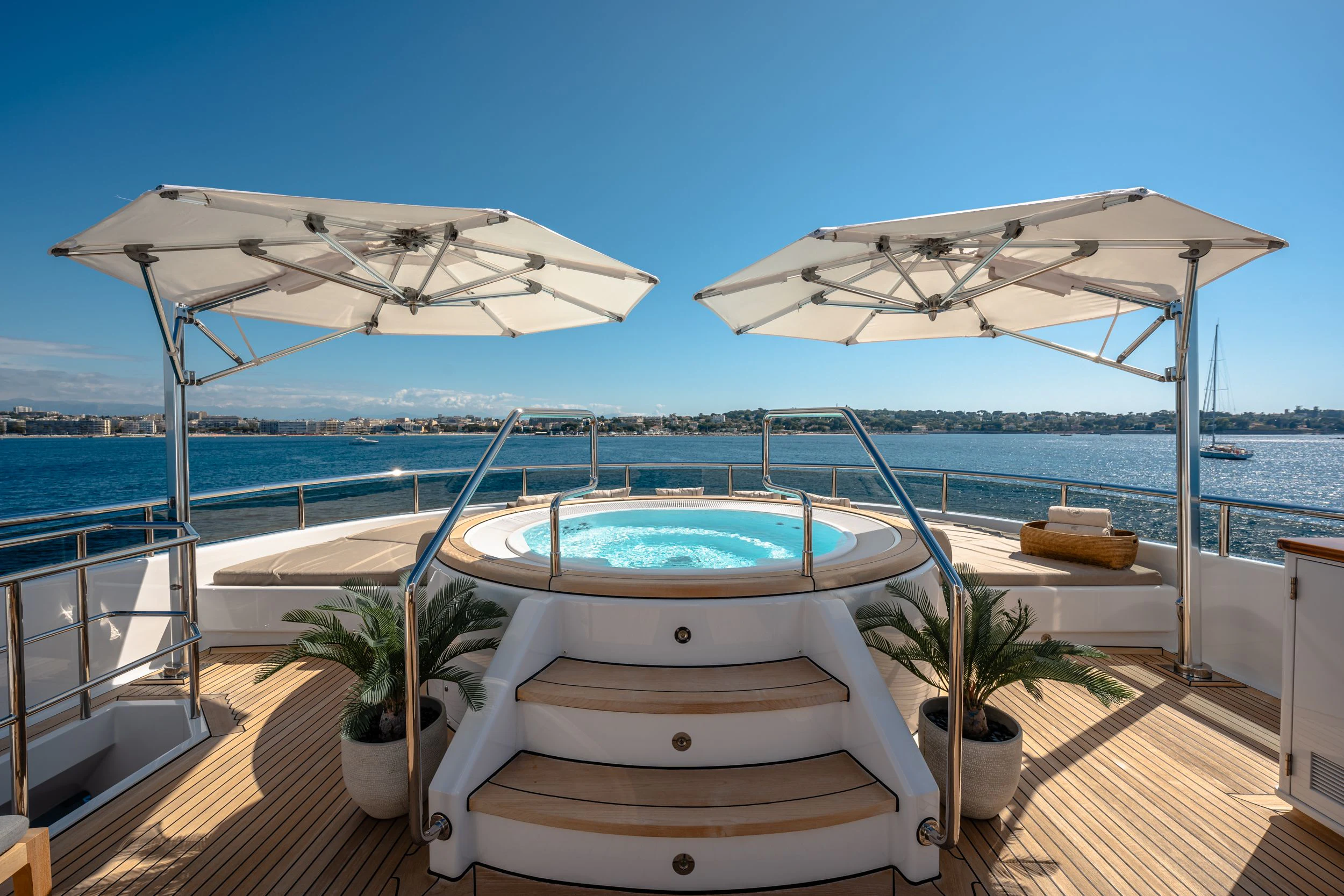 a lounge chair on a deck overlooking a body of water aboard GLADIATOR Yacht for Sale