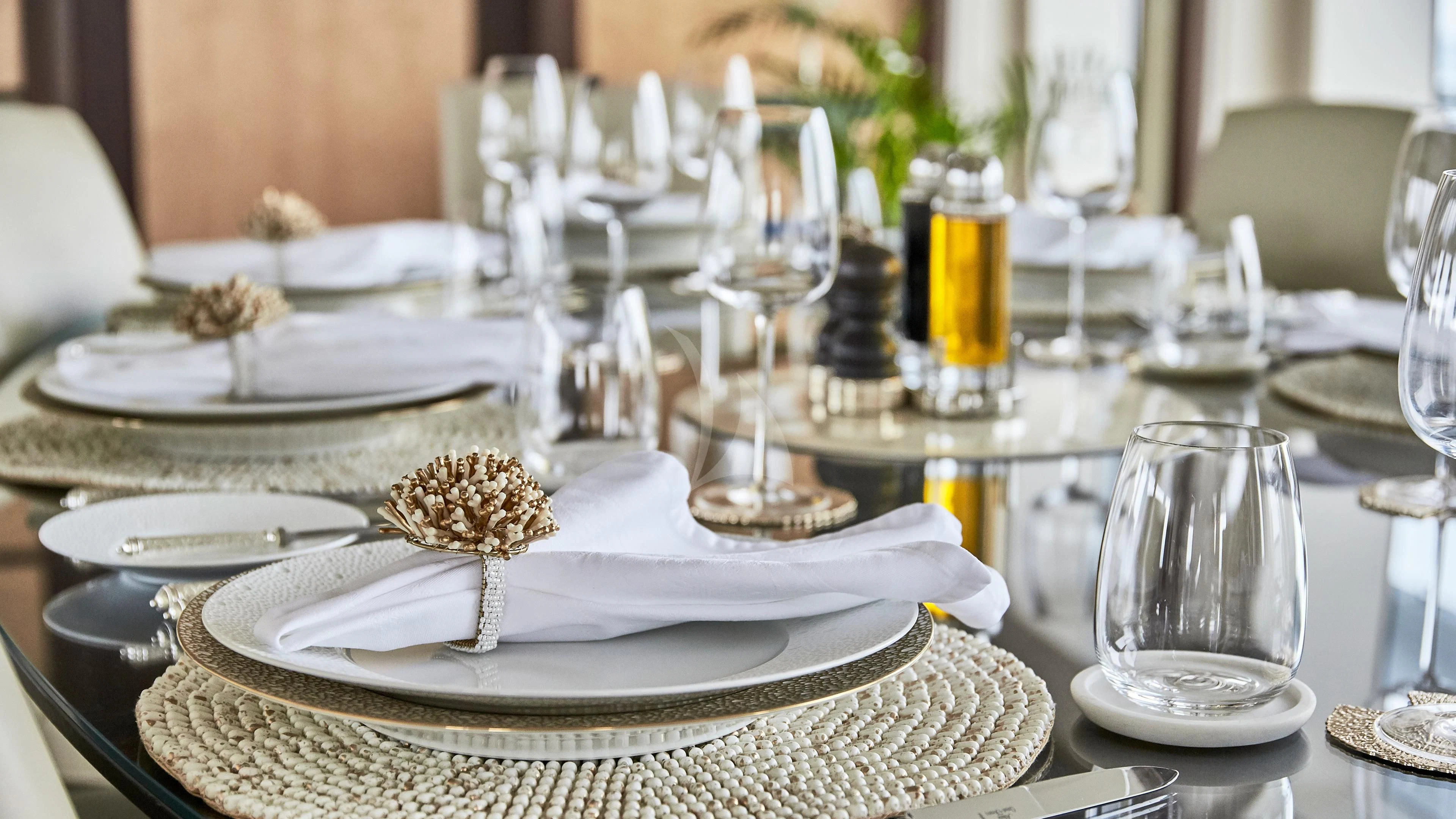 a table with plates and glasses aboard GLADIATOR Yacht for Sale