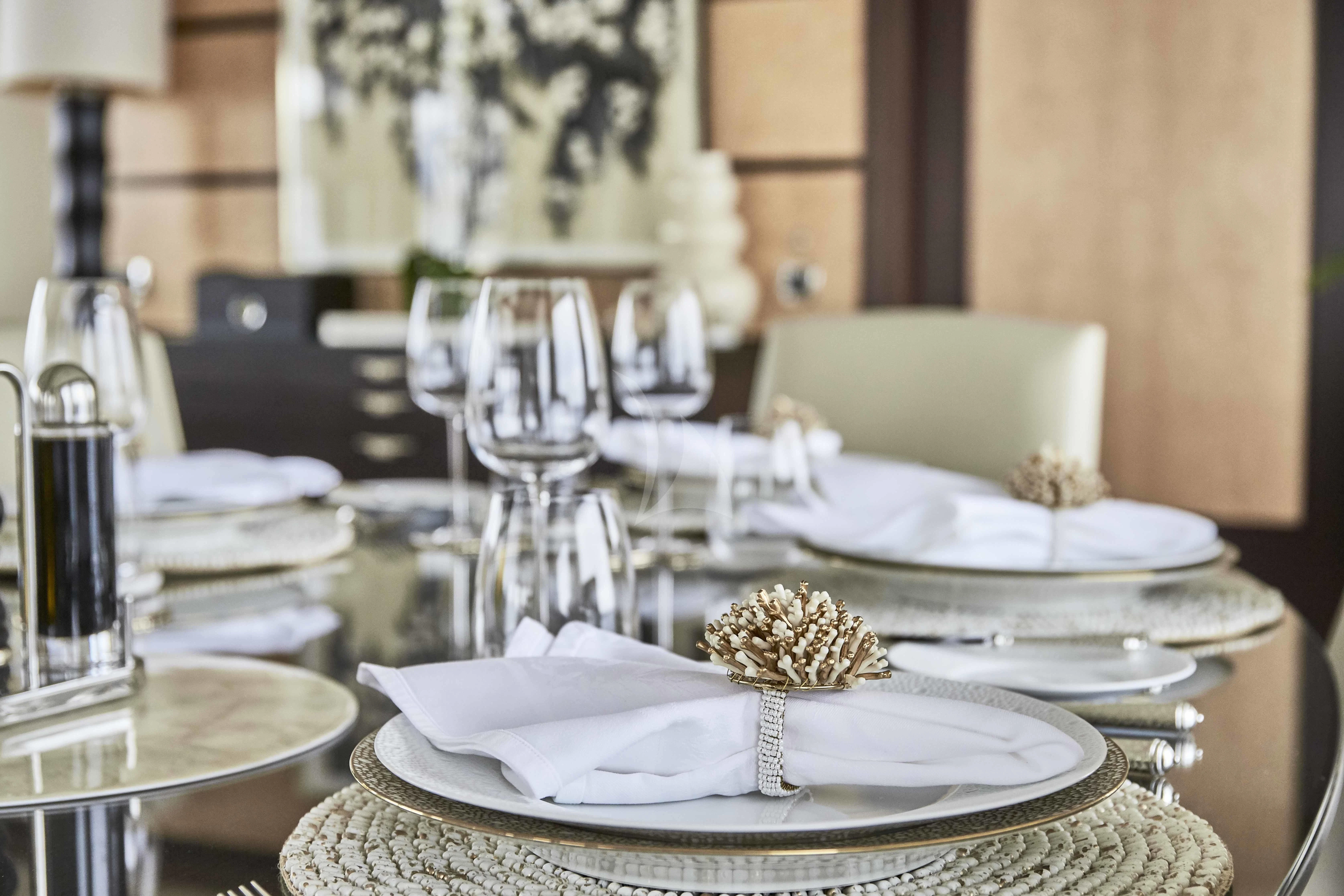 a table with plates and glasses aboard GLADIATOR Yacht for Sale
