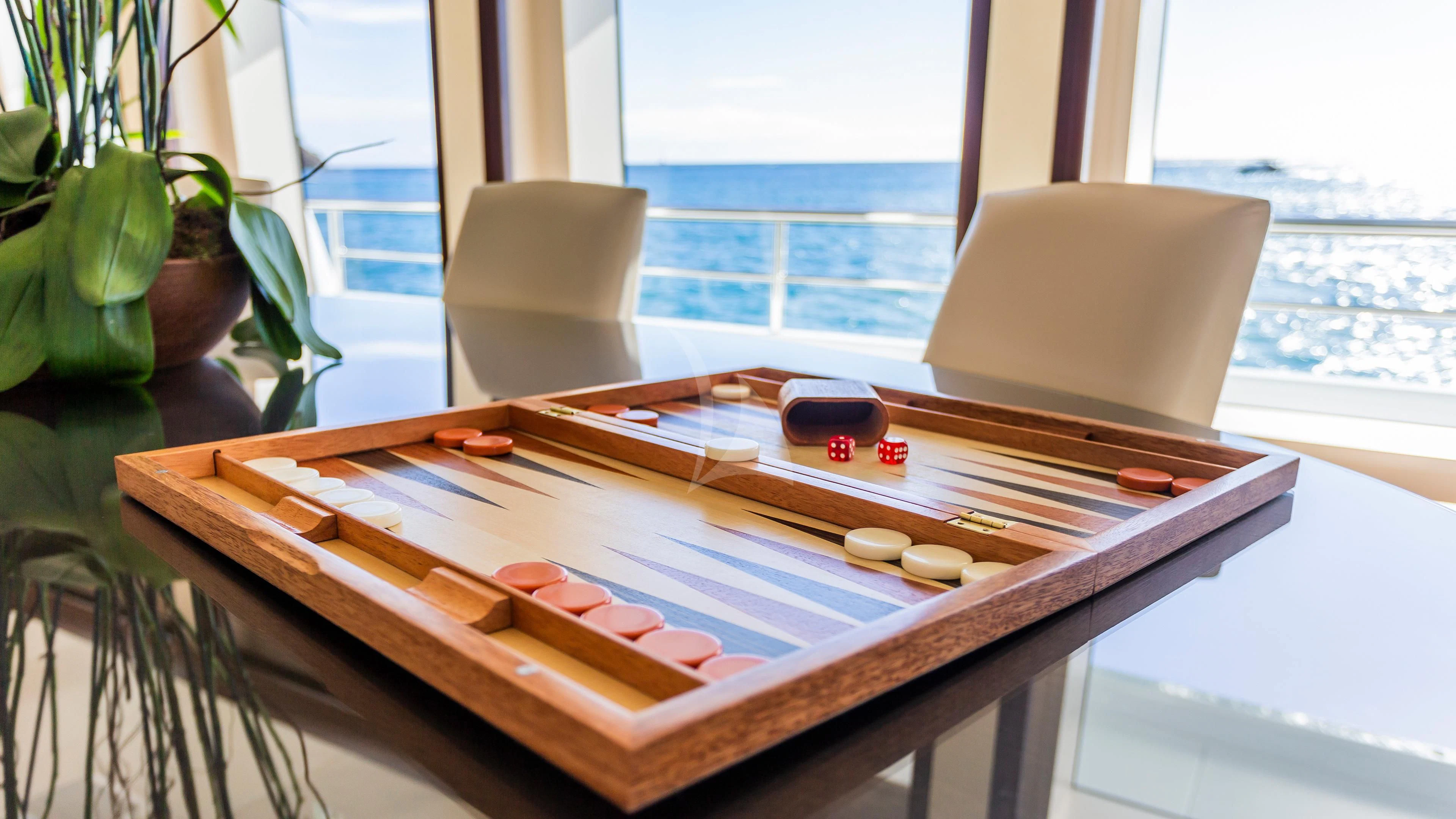 a table with a laptop and a book on it aboard GLADIATOR Yacht for Sale