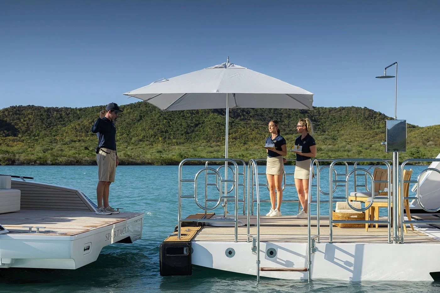 a group of people standing on a boat with an umbrella aboard GLADIATOR Yacht for Sale