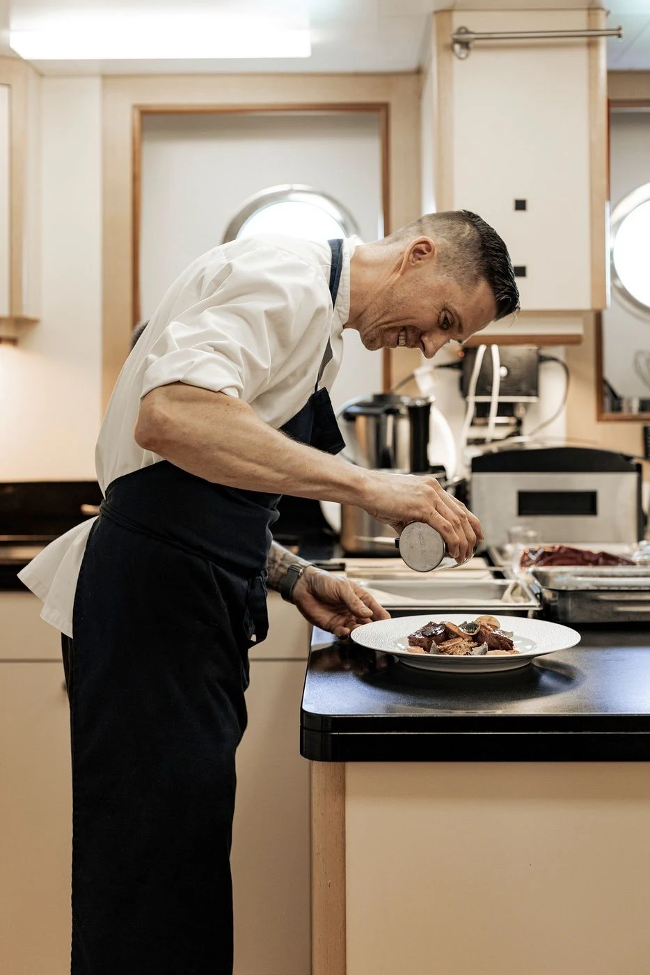 a man cooking food in a kitchen aboard GLADIATOR Yacht for Sale