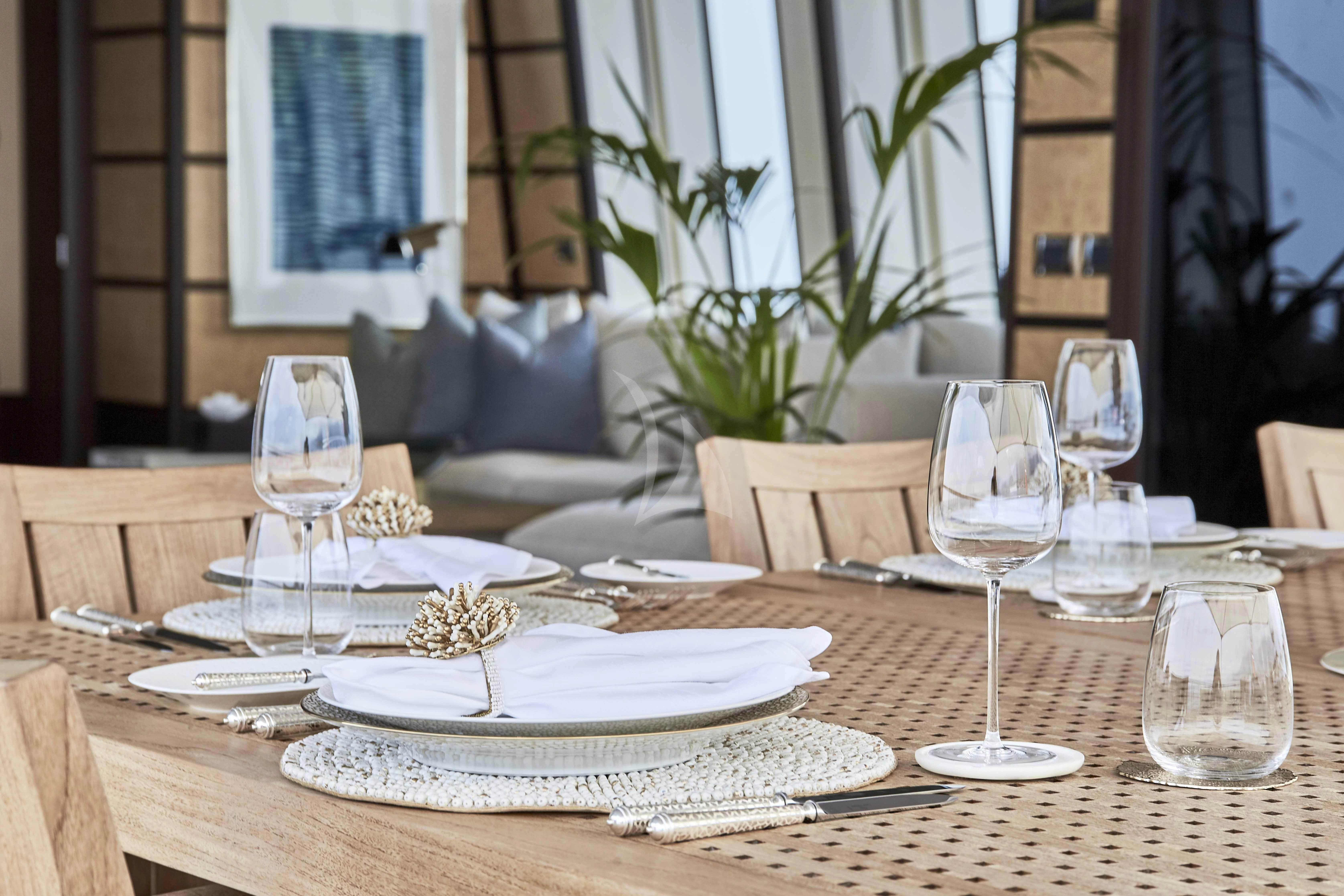 a table with plates and glasses aboard GLADIATOR Yacht for Sale