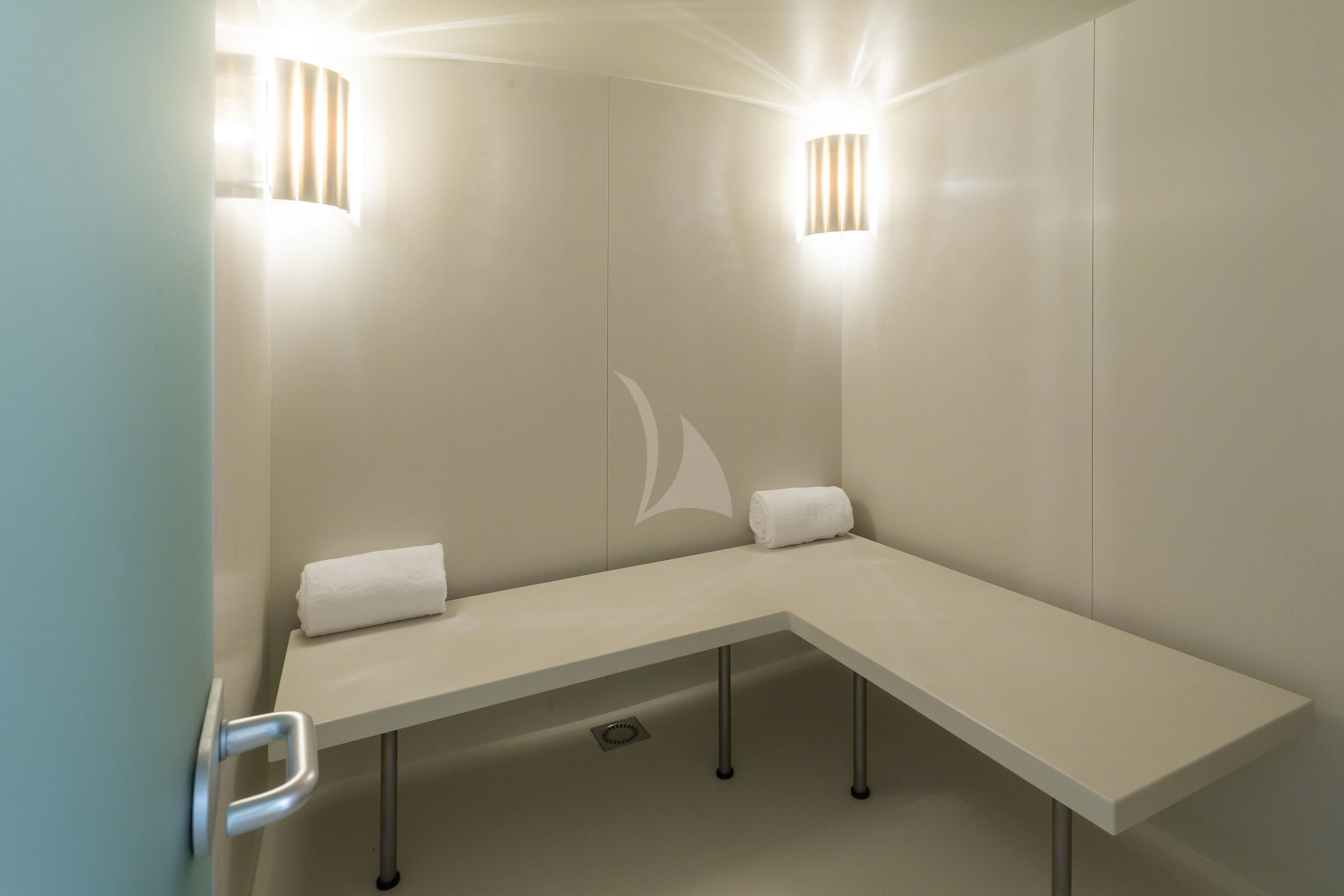 a white table with a white pillow on it aboard GLADIATOR Yacht for Sale