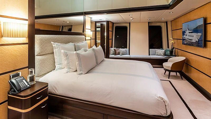 a hotel room with a bed and a phone aboard GLADIATOR Yacht for Sale