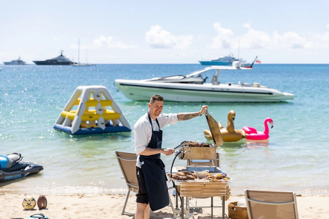 a man sitting at a table with a fishing pole and boats in the background aboard GLADIATOR Yacht for Sale