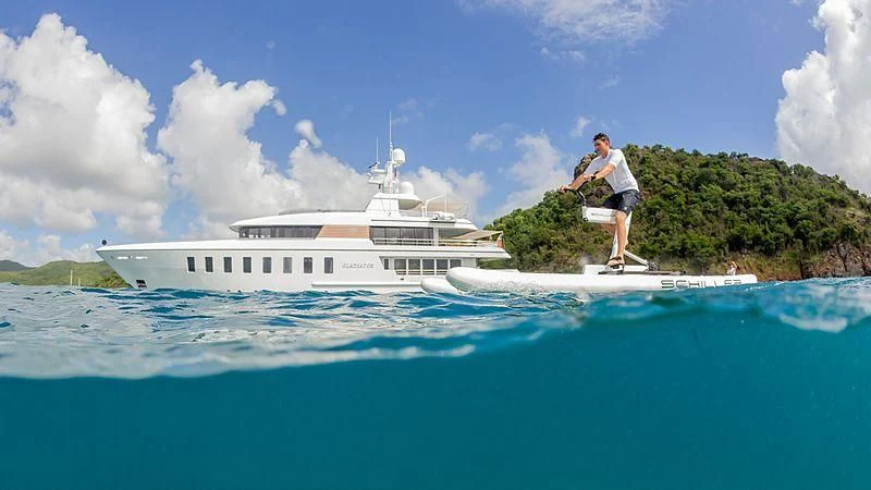a man standing on a dock in front of a white boat aboard GLADIATOR Yacht for Sale