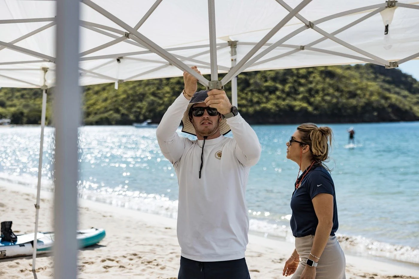a man wearing a white coat and sunglasses on a beach aboard GLADIATOR Yacht for Sale