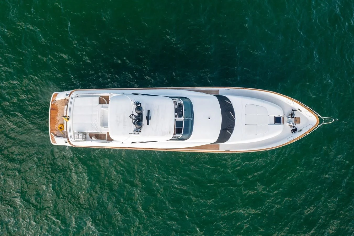 a white and gold boat on green water aboard DOMINIC Yacht for Sale