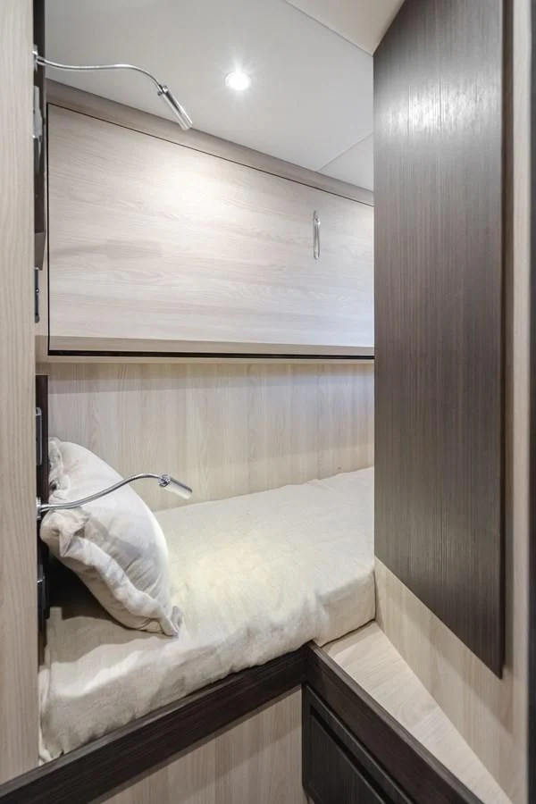 a bed with a light on the wall aboard AZIMUT 25 METRI GRANDE Yacht for Sale