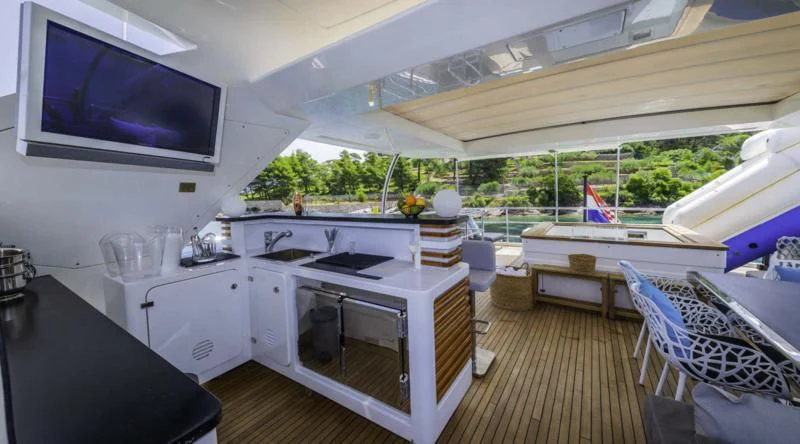 a room with a television and a table and chairs aboard OCEAN DRIVE Yacht for Charter