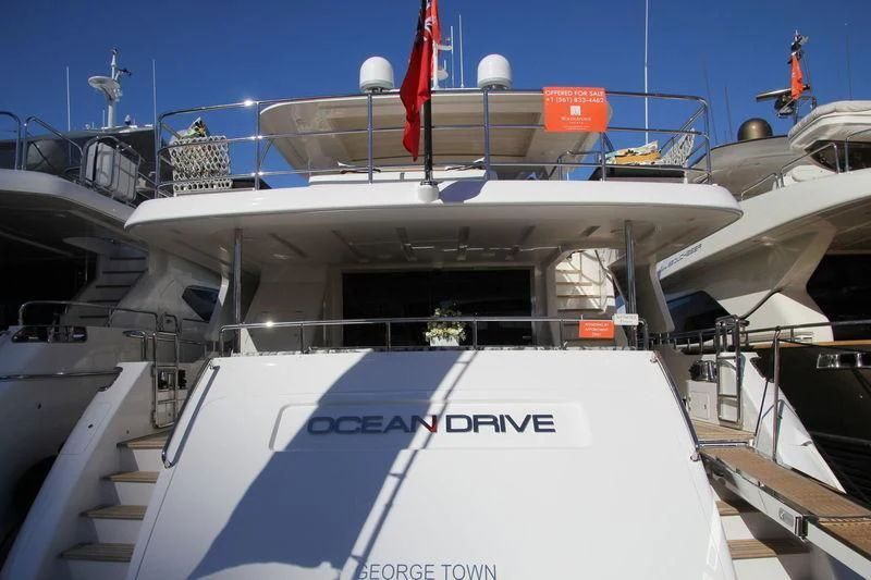 a large white boat with a flag on the front aboard OCEAN DRIVE Yacht for Charter