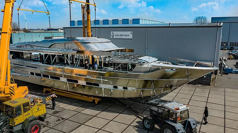 a large machine on the ground with HMS M33 in the background aboard BLUE JEANS Yacht for Sale