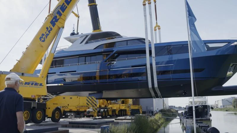 a person standing next to a large boat aboard BLUE JEANS Yacht for Sale