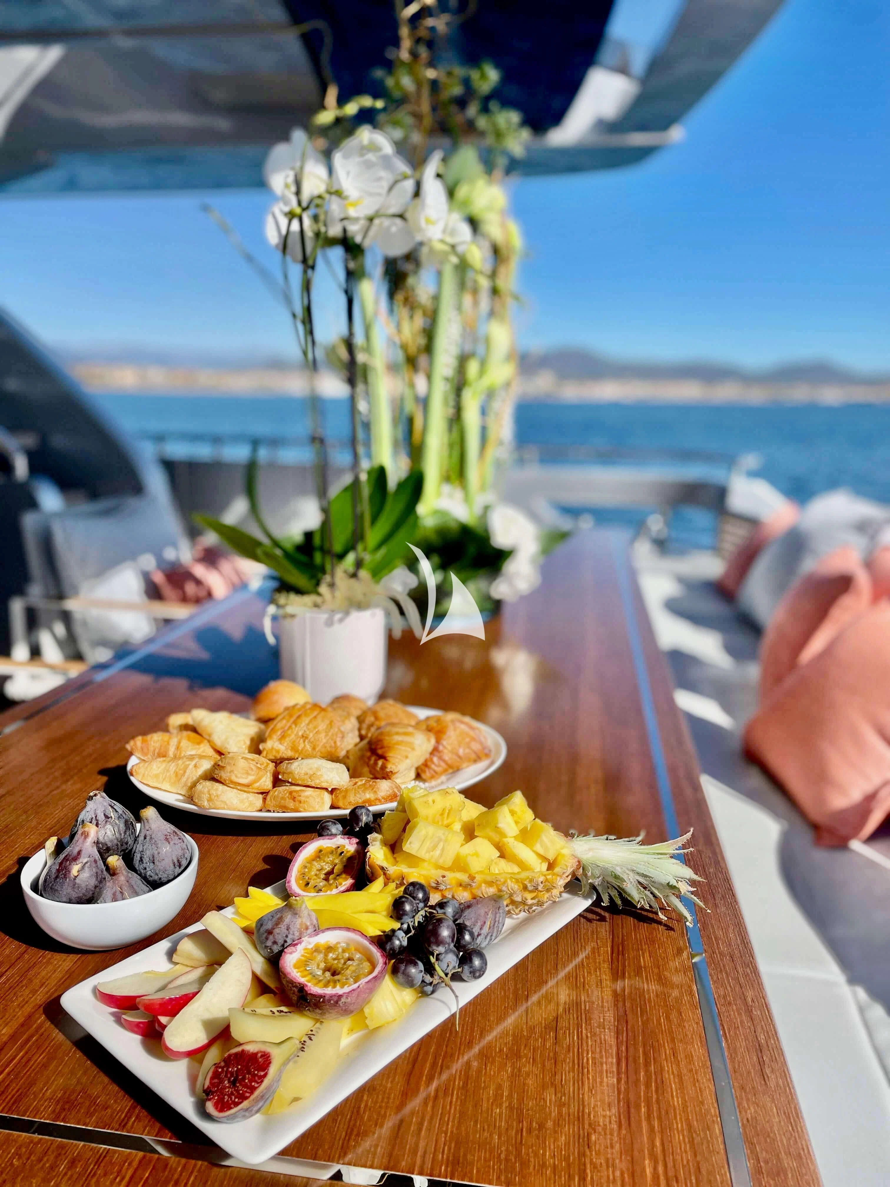 a table with plates of food aboard BASILIC Yacht for Sale