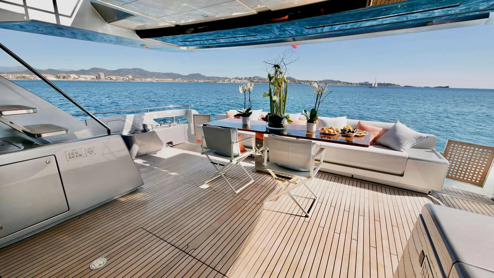 a deck with a table and chairs on it aboard BASILIC Yacht for Sale