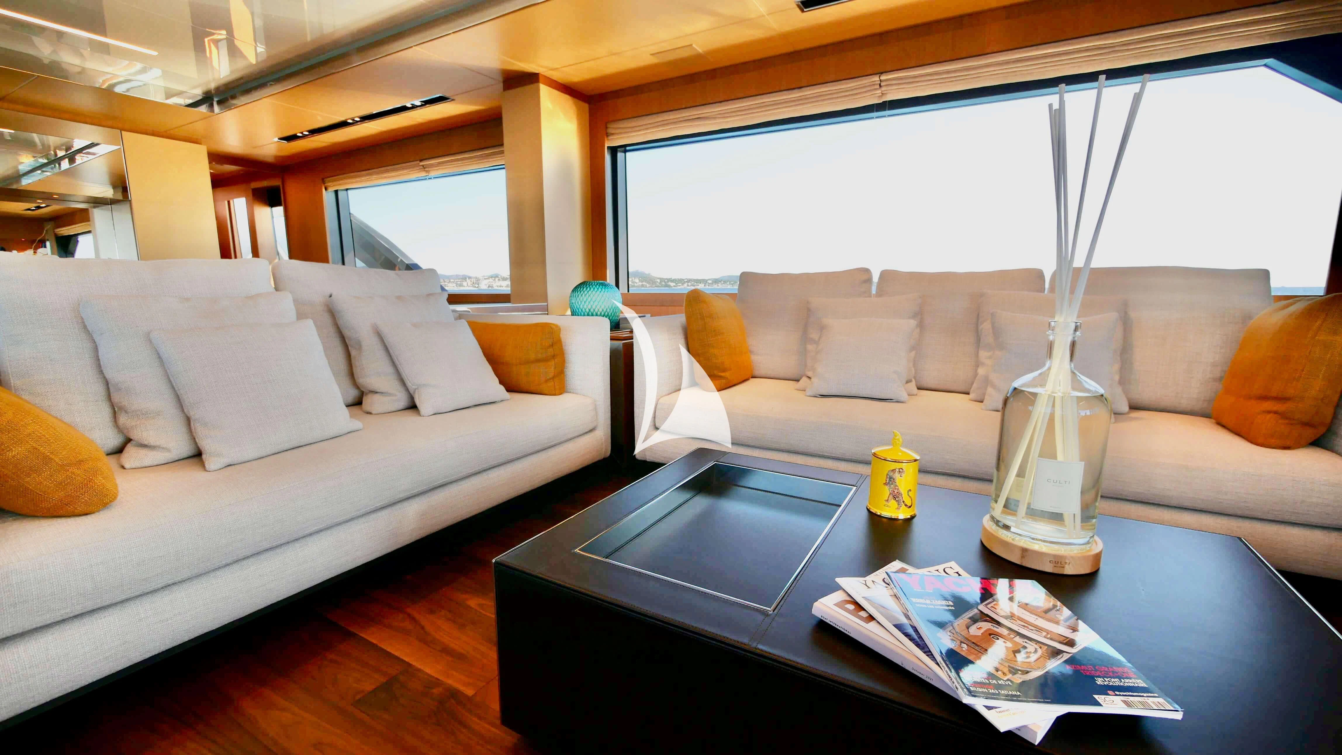 a living room with a glass coffee table and a couch aboard BASILIC Yacht for Sale