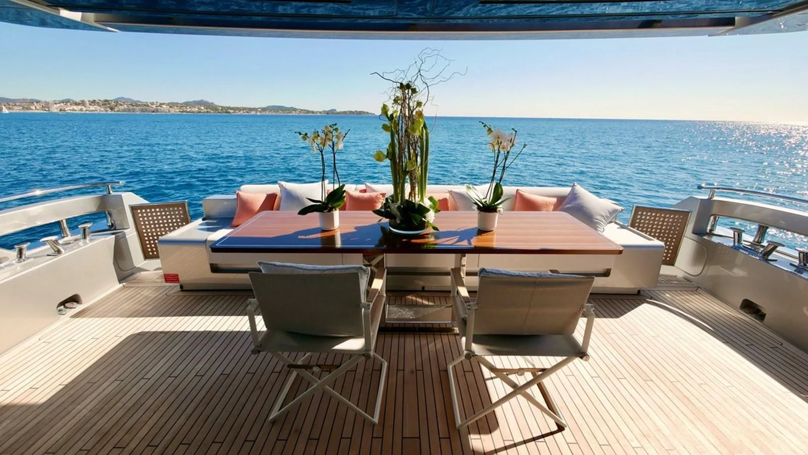 a table with chairs on it next to a body of water aboard BASILIC Yacht for Sale