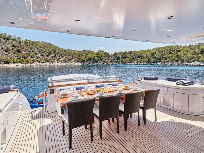 a table and chairs on a deck overlooking a body of water aboard BIANCA Yacht for Sale