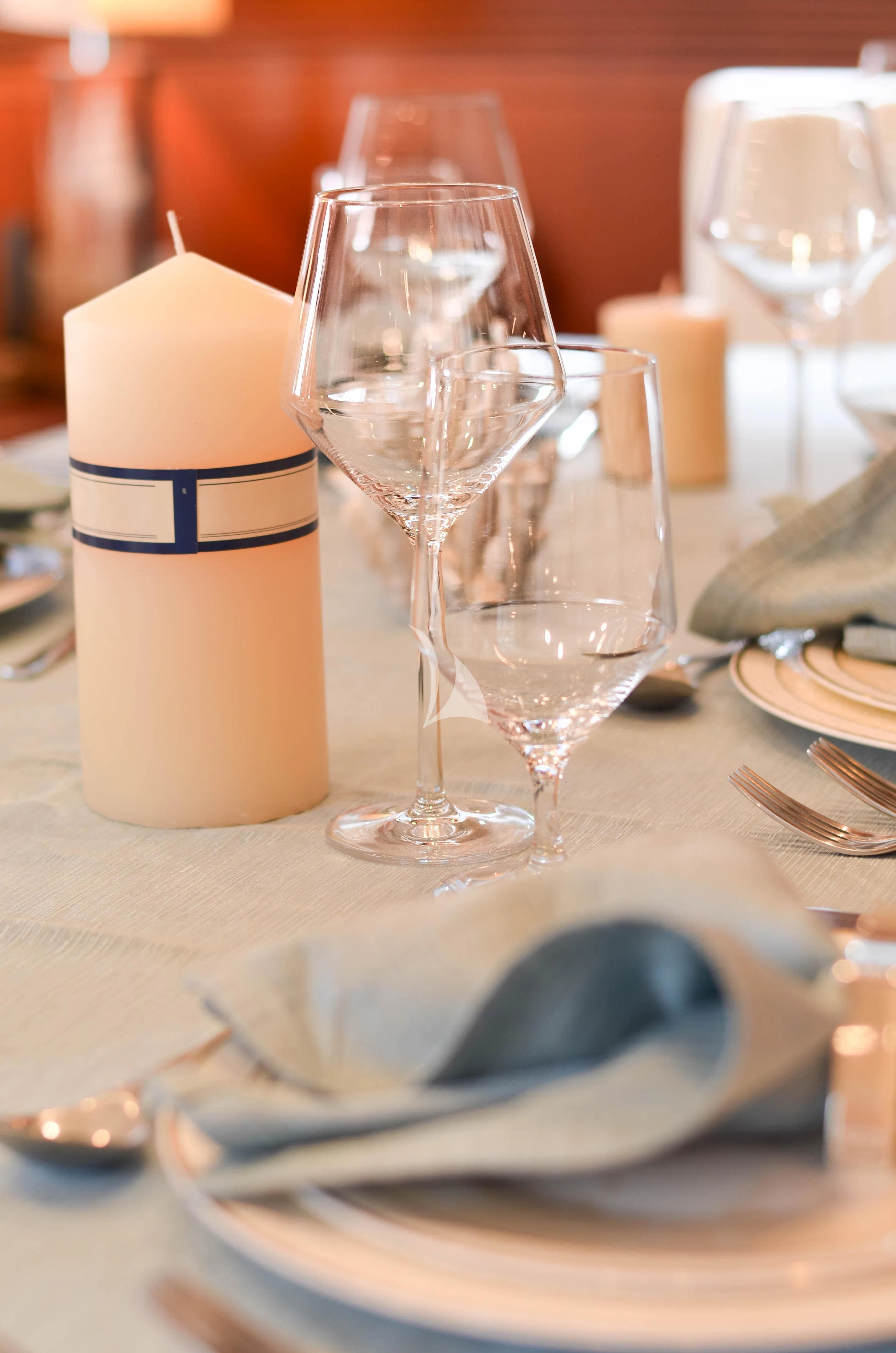 a table with wine glasses and a plate of food aboard BIANCA Yacht for Sale