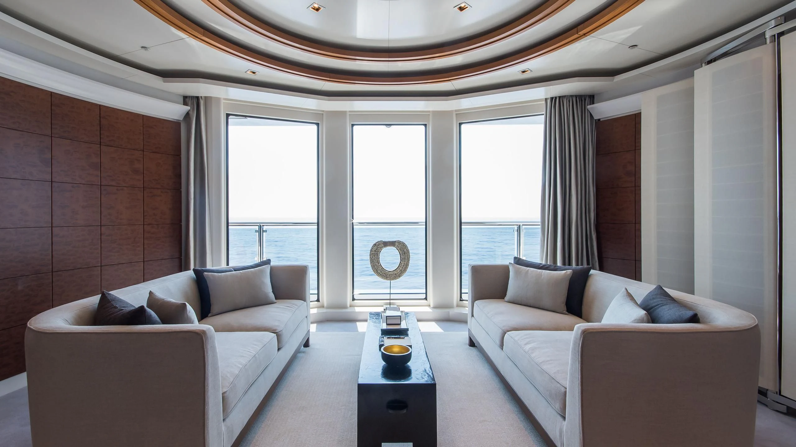 a room with a couch and a table and a window aboard TRIPLE SEVEN Yacht for Sale