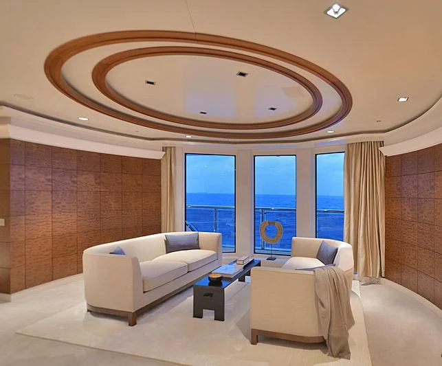 a room with a couch and a large mirror aboard TRIPLE SEVEN Yacht for Sale