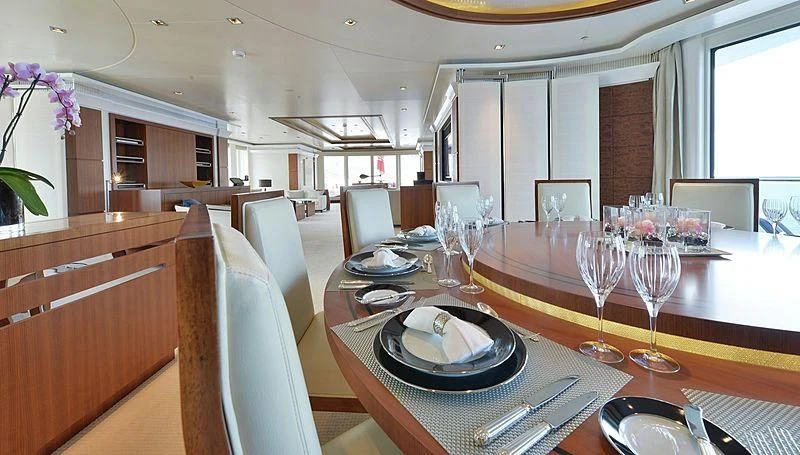 a dining table with plates and glasses aboard TRIPLE SEVEN Yacht for Sale