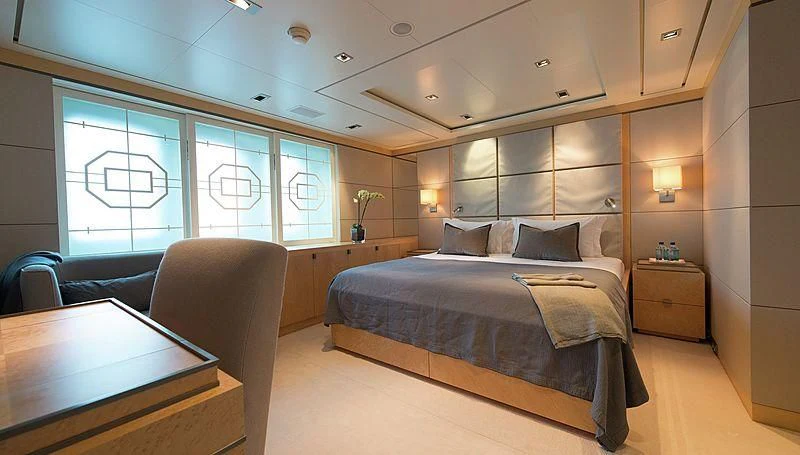 a bedroom with a bed and a desk aboard TRIPLE SEVEN Yacht for Sale