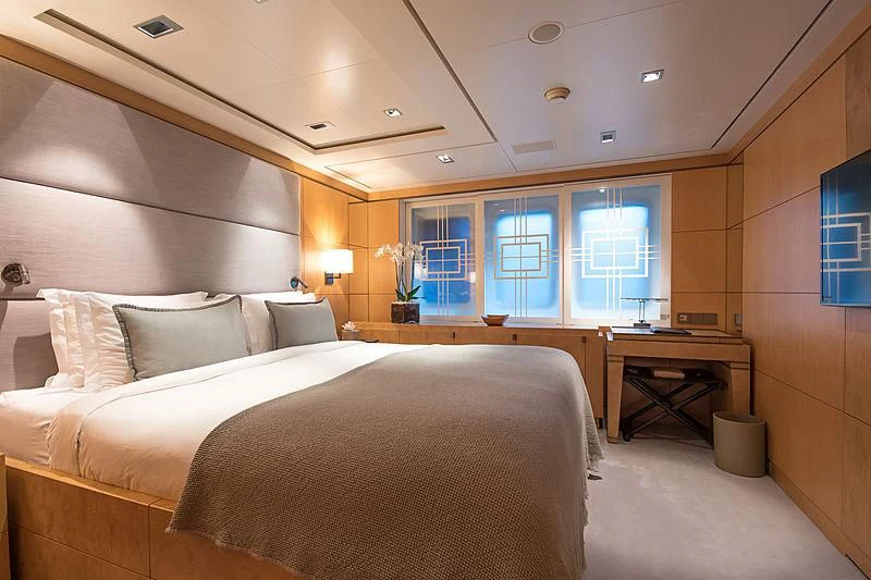 a hotel room with a bed and desk aboard TRIPLE SEVEN Yacht for Sale
