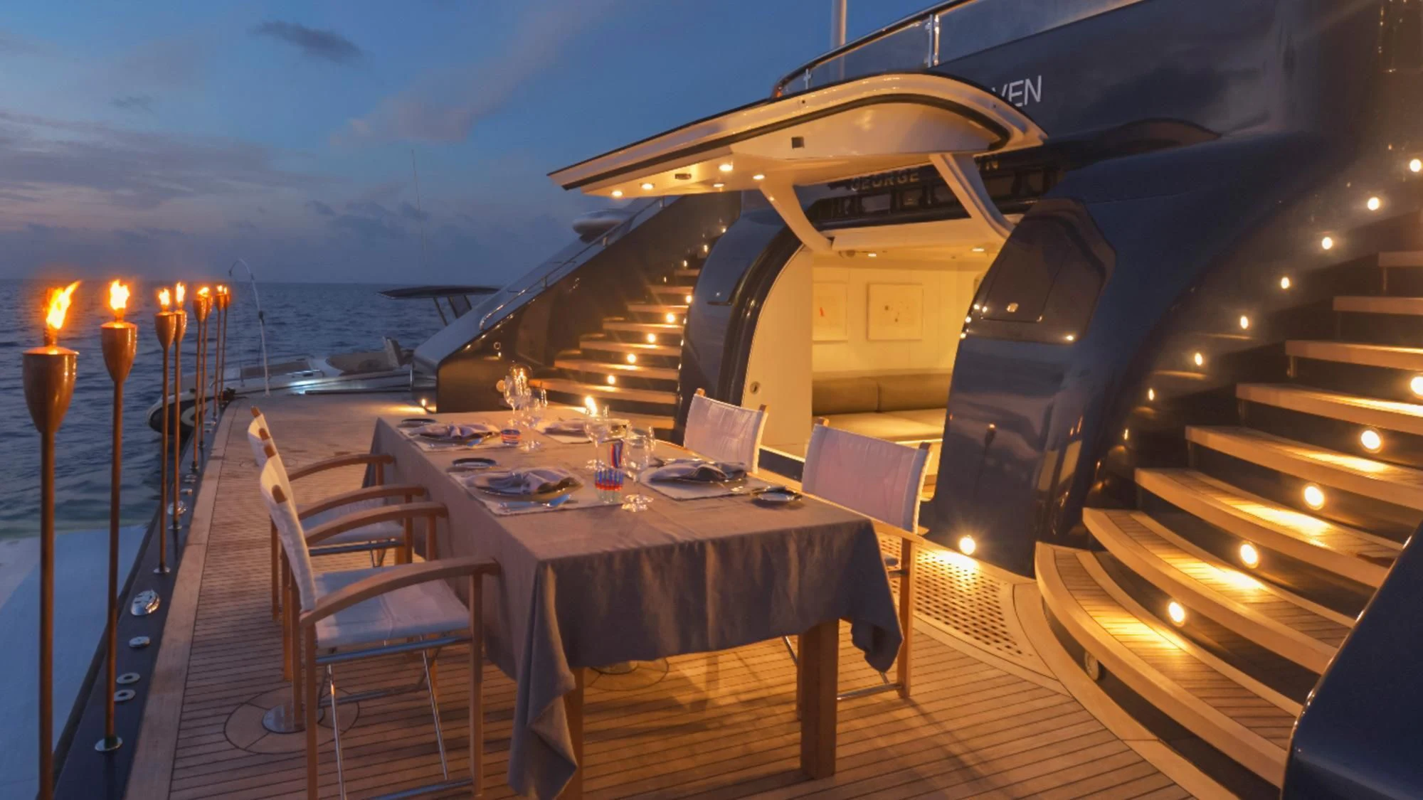 a table and chairs on a deck aboard TRIPLE SEVEN Yacht for Sale