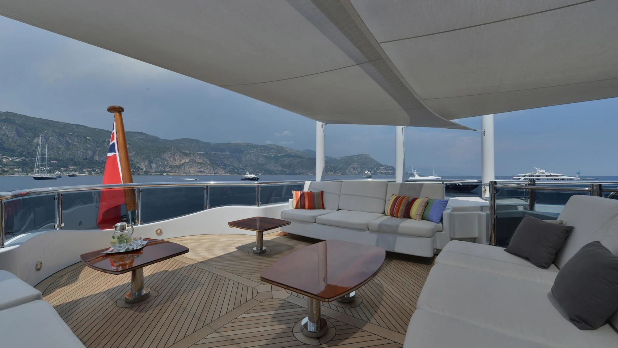 a large white lounge chair in a living room with a large body of water and a large sail aboard TRIPLE SEVEN Yacht for Sale