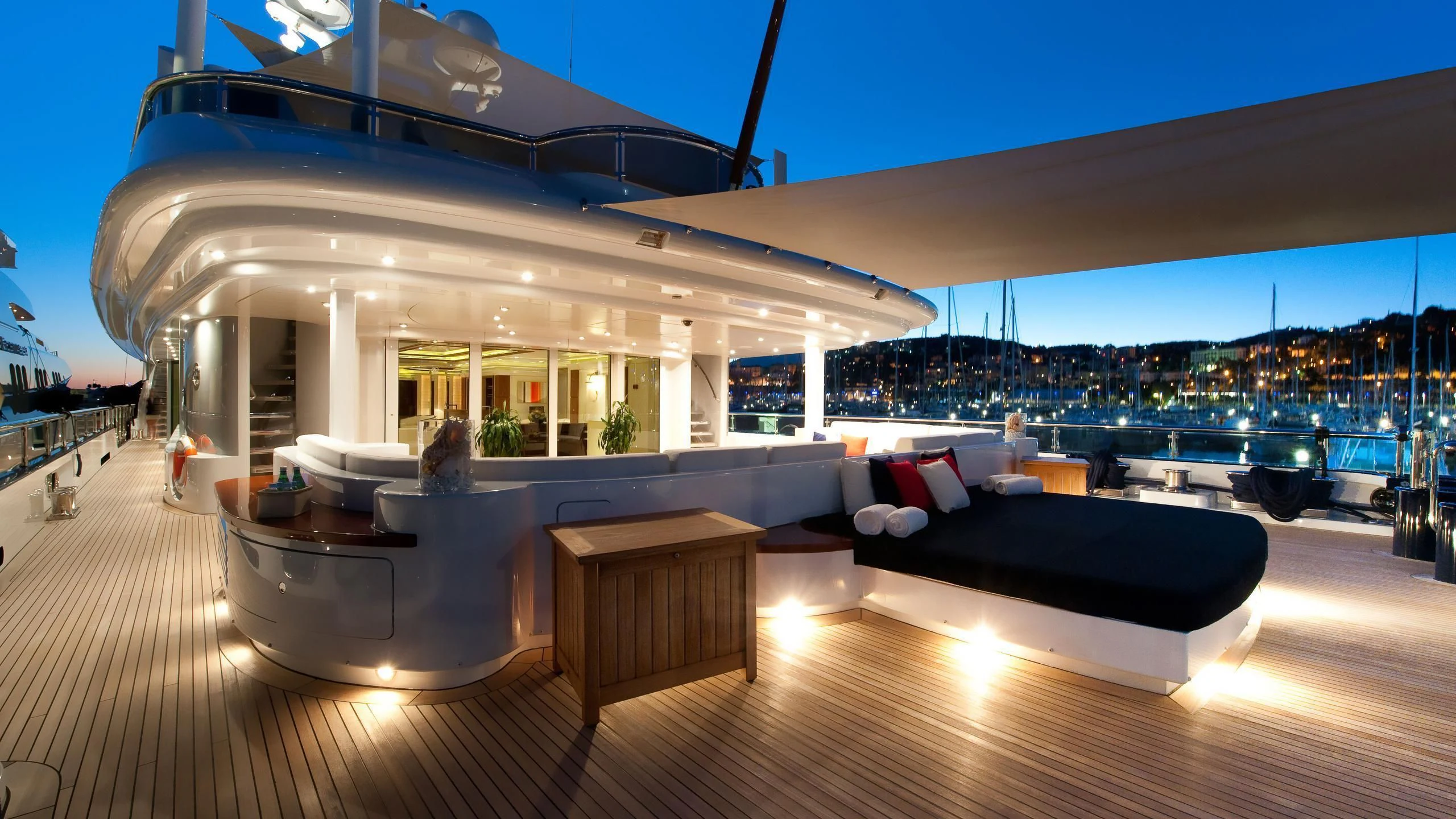 a large lounge area with a large yacht in the background aboard TRIPLE SEVEN Yacht for Sale