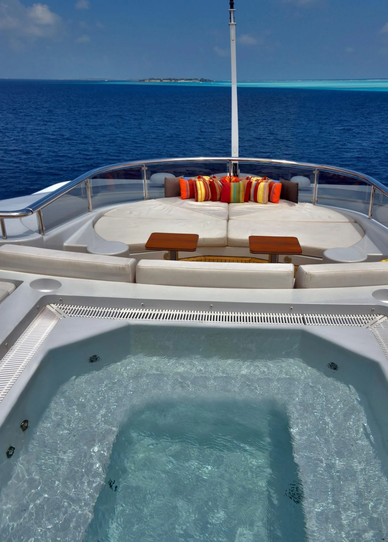 a pool with a straw on the deck and a railing and a blue sky aboard TRIPLE SEVEN Yacht for Sale