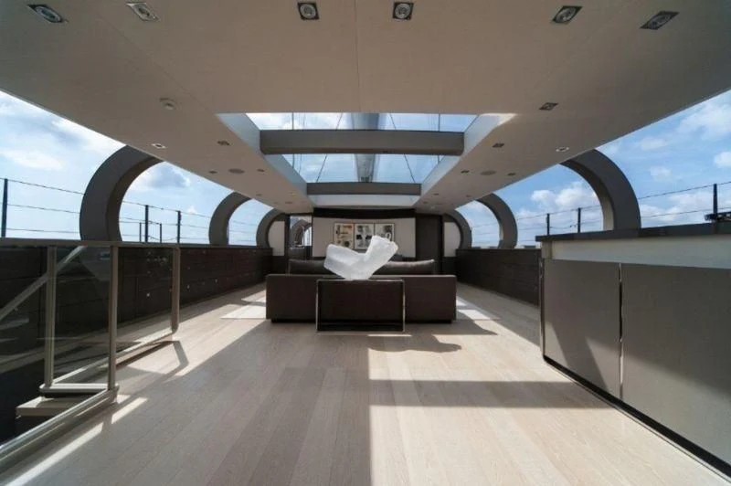 a room with a couch and a large window aboard ANATTA Yacht for Sale