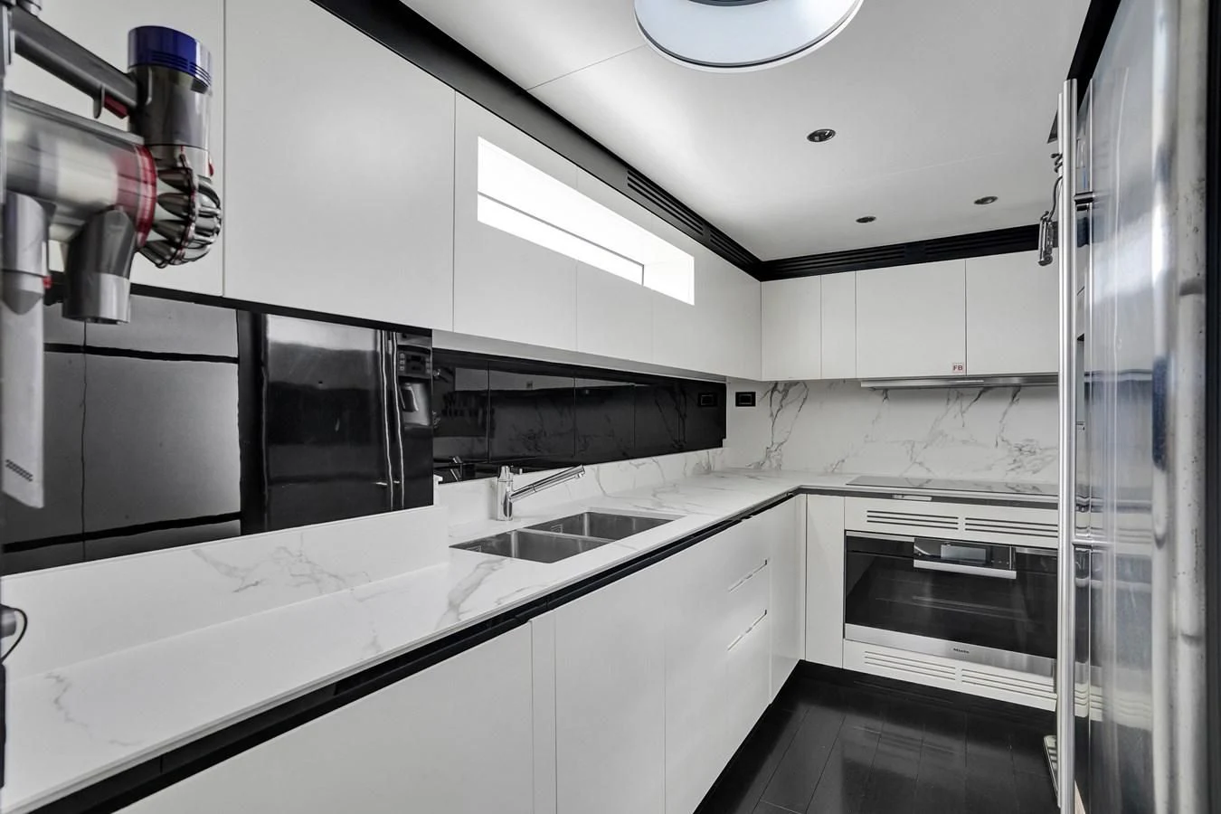 a kitchen with white cabinets aboard ENCHANTE Yacht for Sale