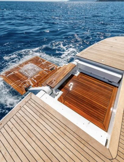 a wooden deck with a wood railing and a body of water in the background aboard CARITA Yacht for Sale