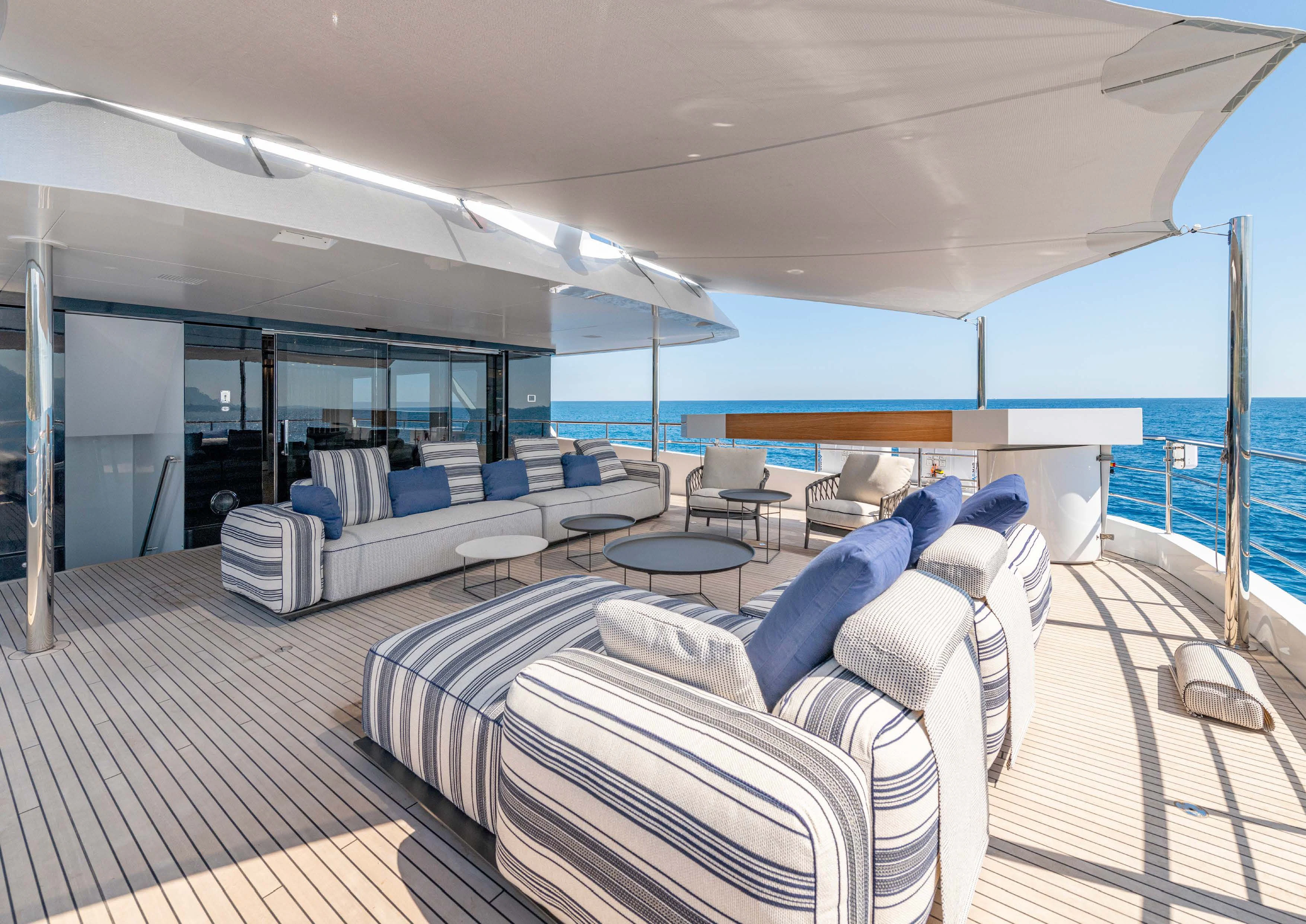 a large room with a deck and chairs aboard CARITA Yacht for Sale