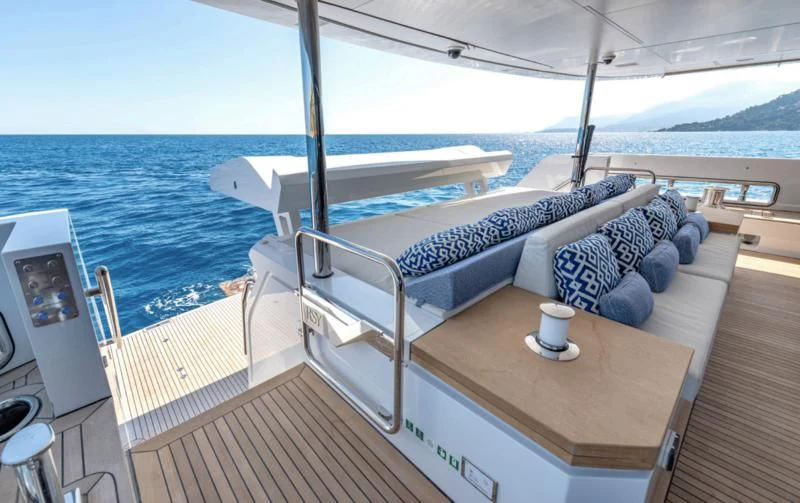 a deck with a large bed and a table on it aboard CARITA Yacht for Sale
